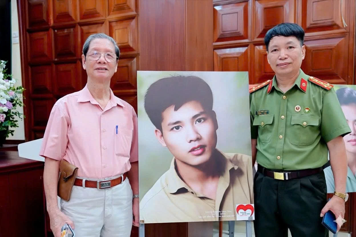 Anh Nguyễn Văn Thục (trái), anh trai liệt sĩ Nguyễn Văn Thạc và nhà thơ Đặng Vương Hưng (phải) với tấm ảnh Nguyễn Văn Thạc phục chế - Ảnh:GĐCC